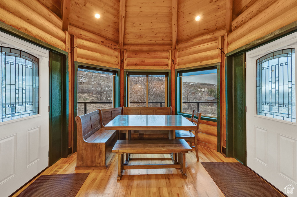 Dining room with plenty of natural light, light hardwood / wood-style floors, and rustic walls