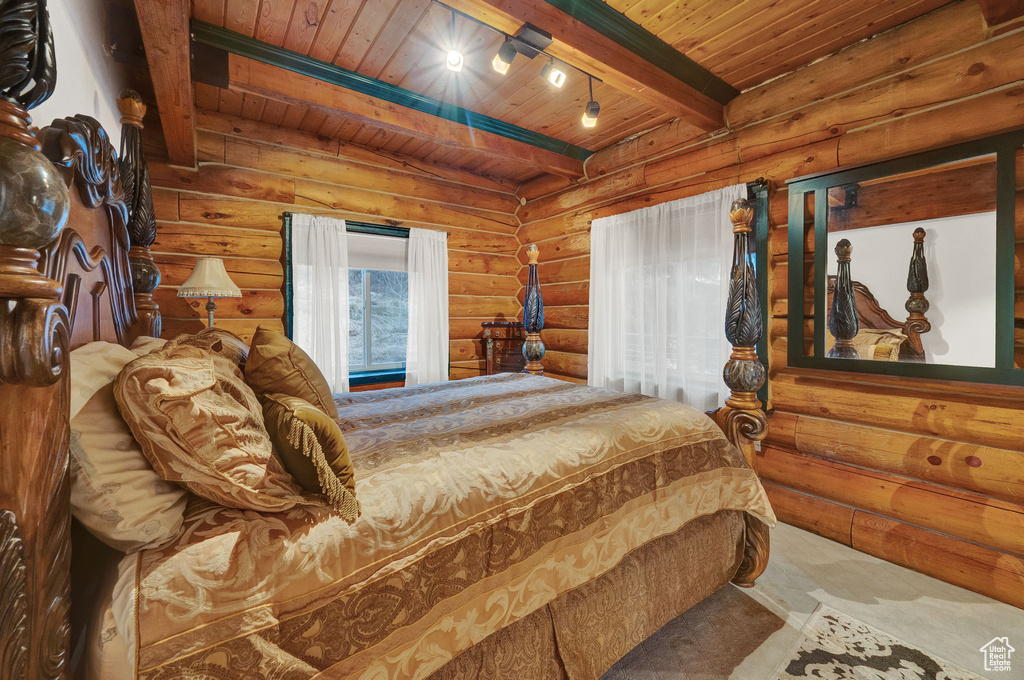 Bedroom featuring wooden ceiling, beam ceiling, and rustic walls