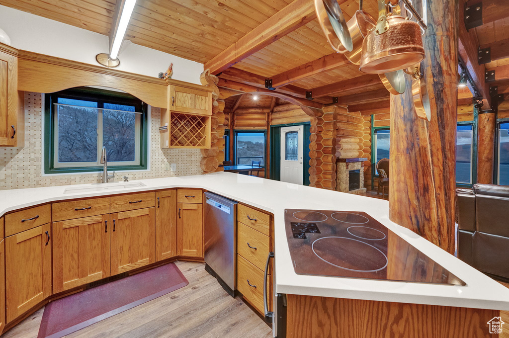 Kitchen with beamed ceiling, sink, tasteful backsplash, and log walls