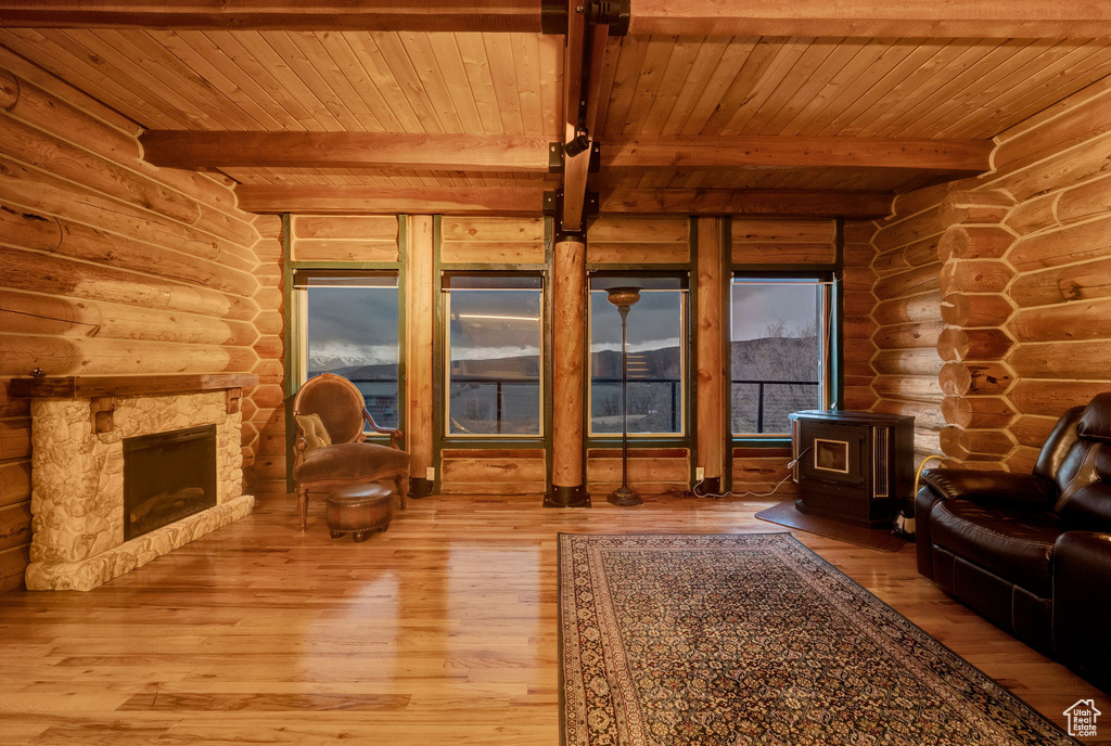 Living room with log walls, beam ceiling, and hardwood / wood-style flooring