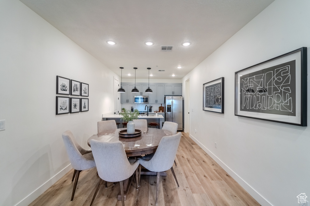 Dining room featuring sink and light hardwood / wood-style flooring