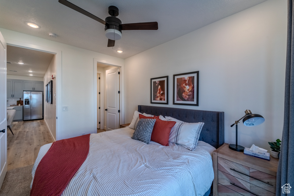 Bedroom with ceiling fan, stainless steel fridge, and light wood-type flooring