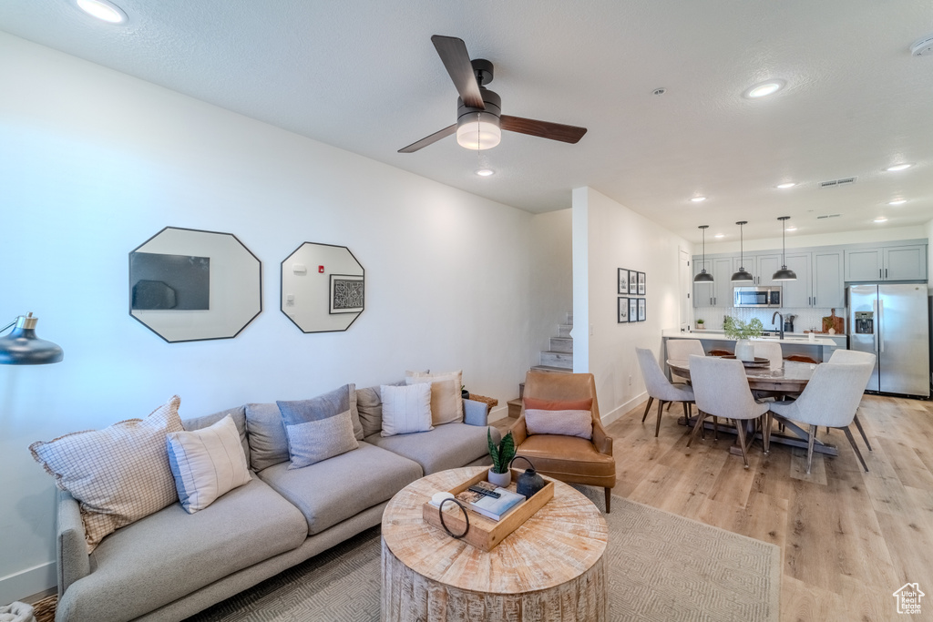 Living room featuring light hardwood / wood-style flooring, ceiling fan, and sink