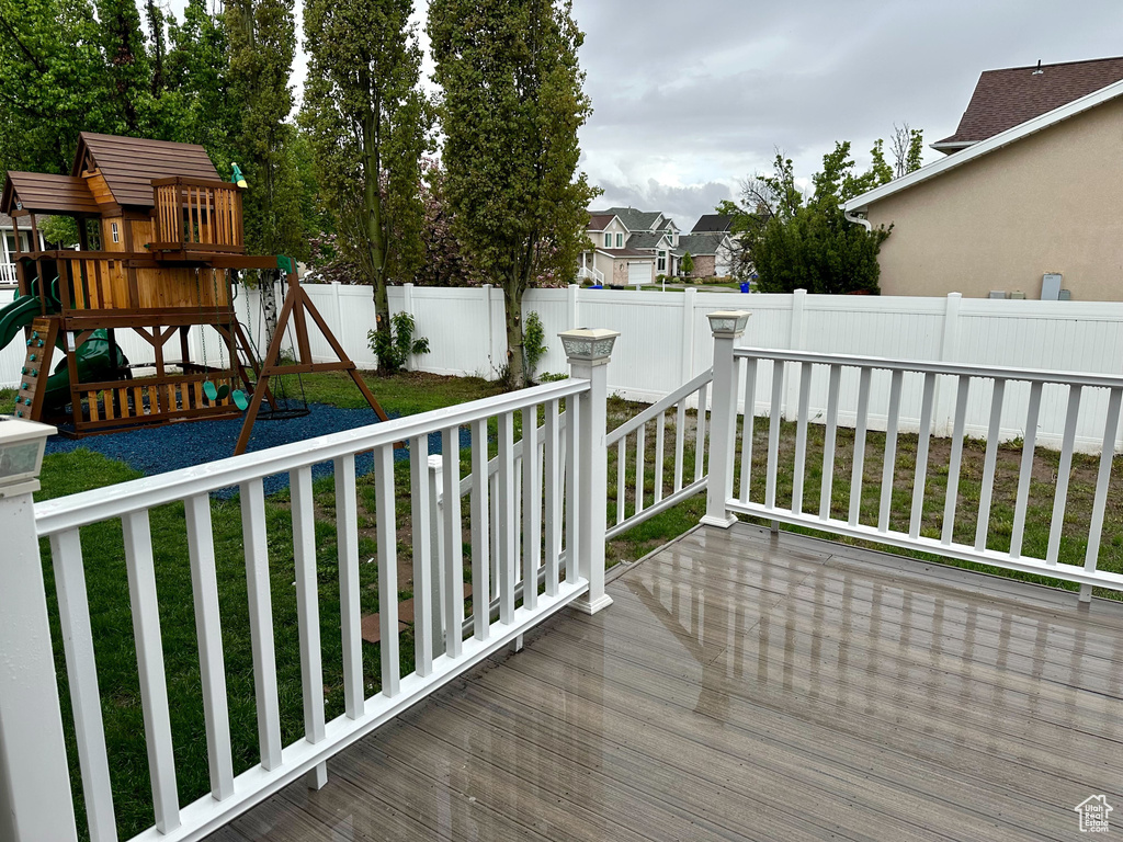 Wooden terrace featuring a yard and a playground