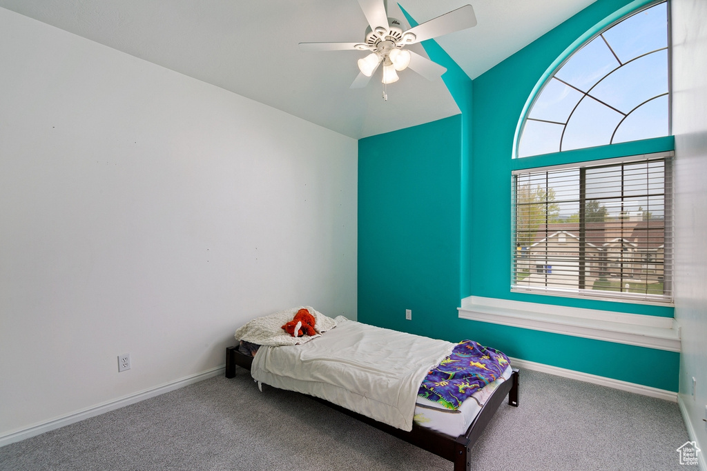 Unfurnished bedroom with carpet, ceiling fan, and vaulted ceiling