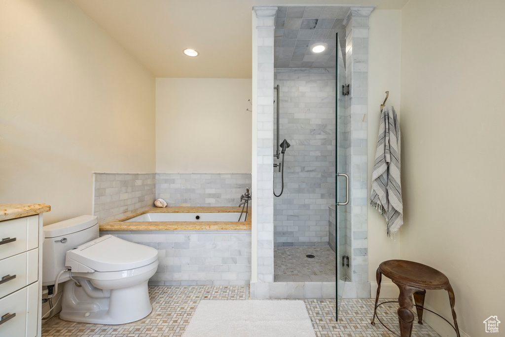 Full bathroom featuring plus walk in shower, vanity, tile floors, and toilet