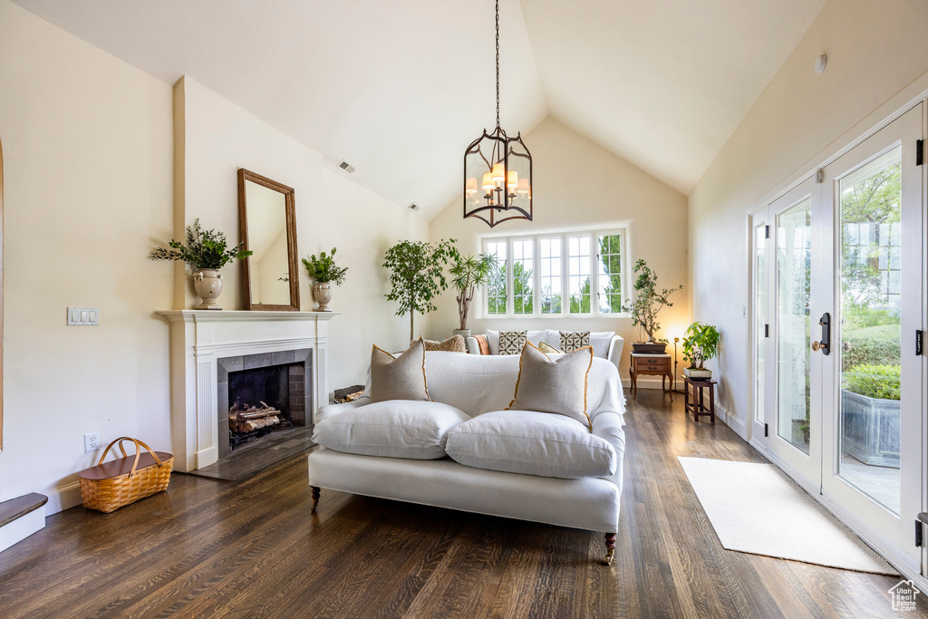 Living room featuring dark hardwood / wood-style floors, high vaulted ceiling, and an inviting chandelier