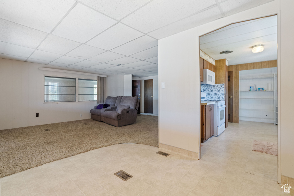 Unfurnished living room with light carpet and a paneled ceiling