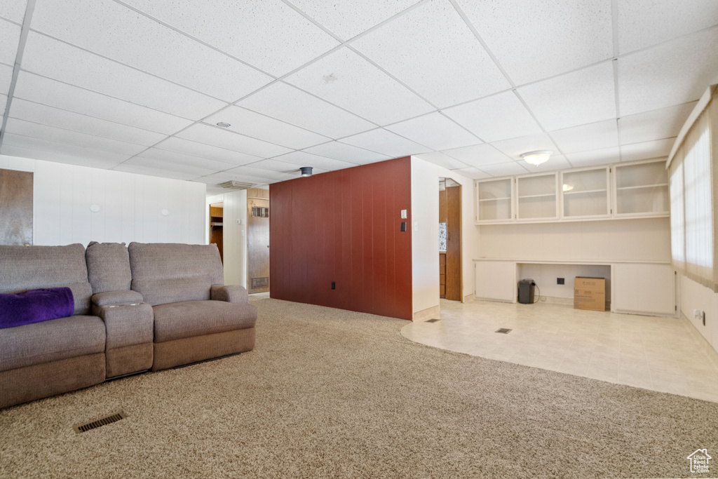 Carpeted living room with a paneled ceiling