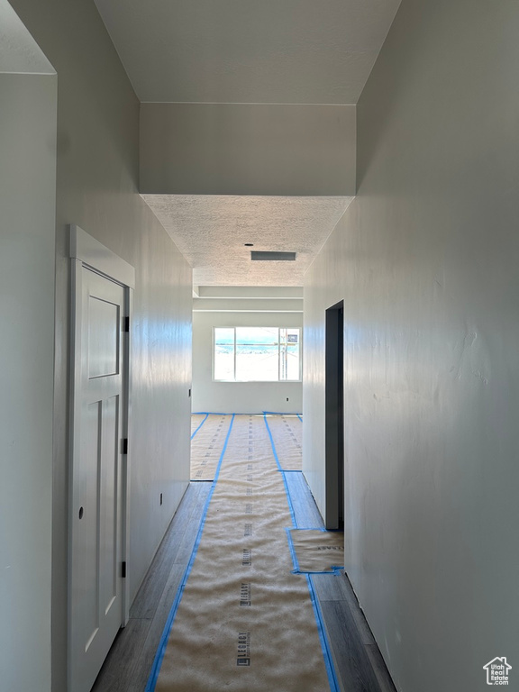 Hallway featuring a textured ceiling and light wood-type flooring