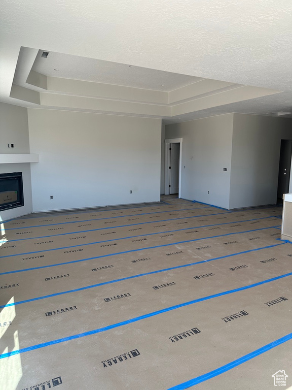Unfurnished living room with a tray ceiling