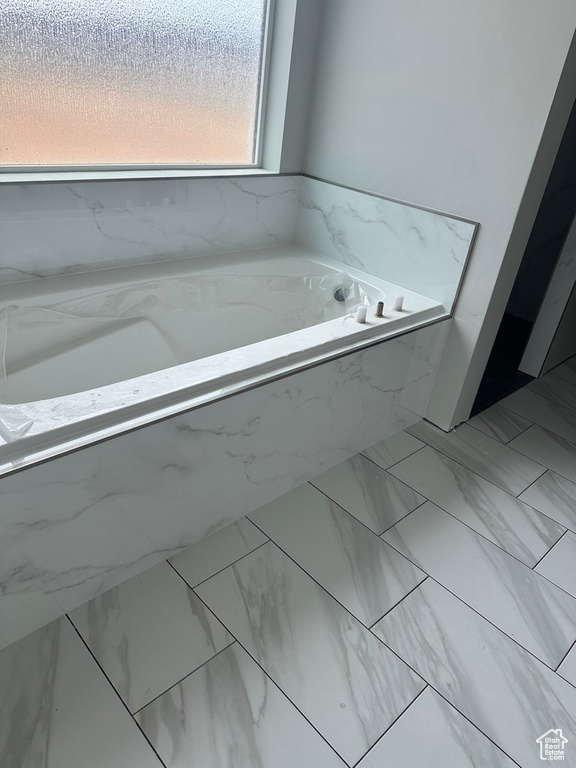 Bathroom featuring a bath and tile flooring
