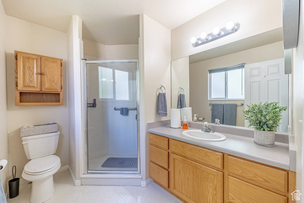 Bathroom featuring walk in shower, toilet, tile floors, and vanity