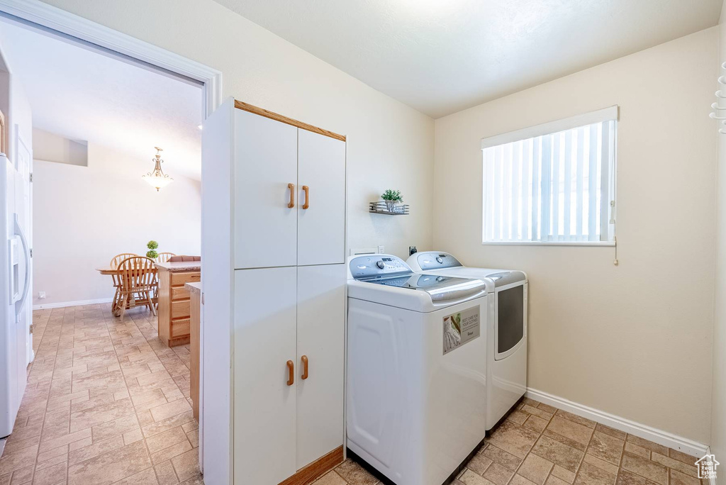 Laundry room with light tile flooring and washing machine and clothes dryer