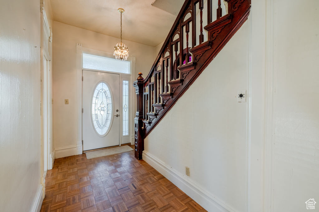 Entrance foyer with a chandelier and parquet flooring