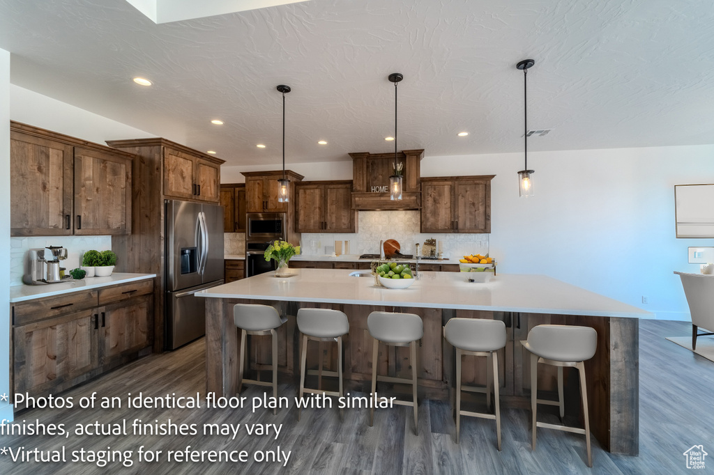 Kitchen with tasteful backsplash, stainless steel appliances, and dark hardwood / wood-style floors