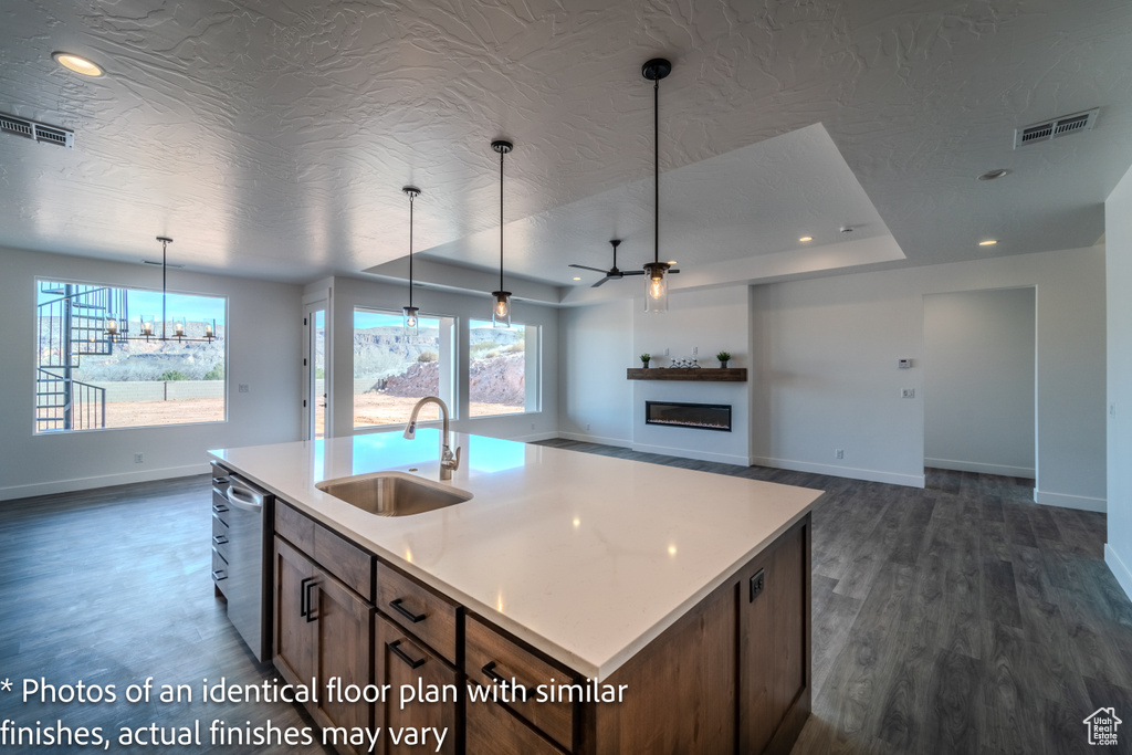 Kitchen featuring plenty of natural light, sink, decorative light fixtures, and a kitchen island with sink