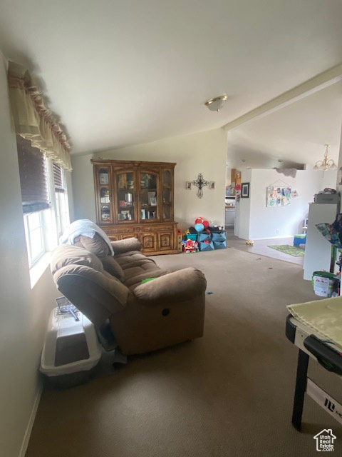 Carpeted living room featuring lofted ceiling