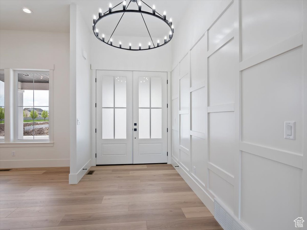 Interior space featuring a notable chandelier, light hardwood / wood-style floors, and french doors