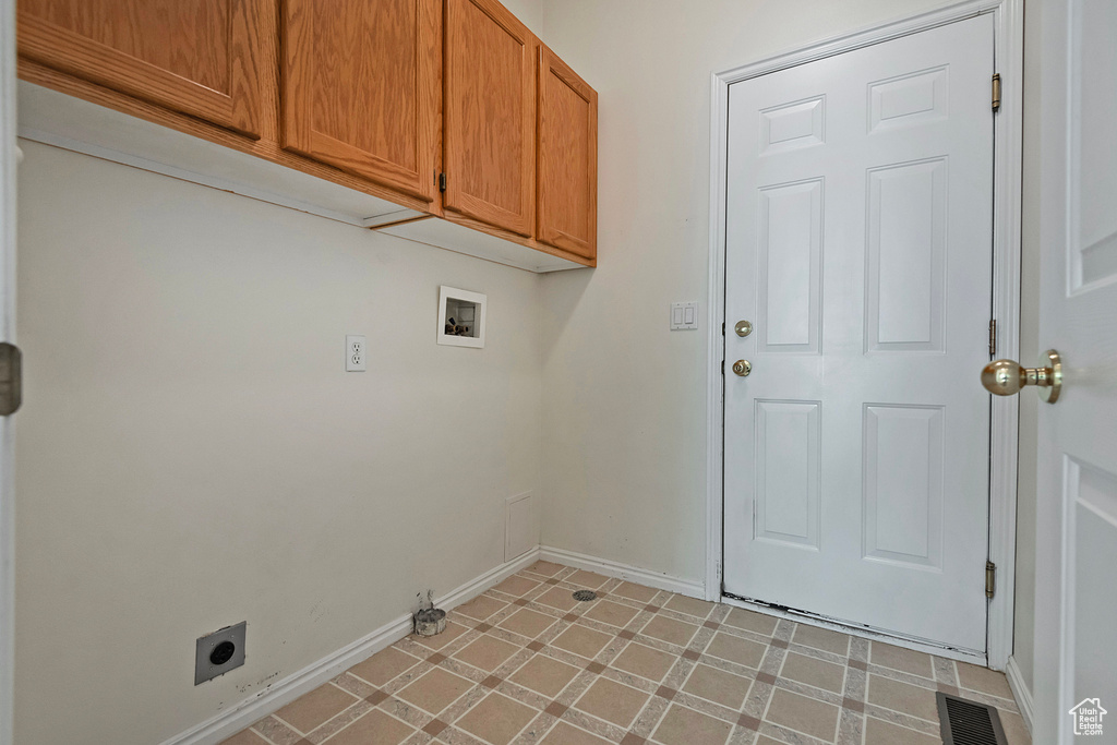 Laundry room featuring cabinets, hookup for a washing machine, light tile flooring, and electric dryer hookup