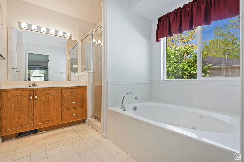 Bathroom with independent shower and bath, oversized vanity, a healthy amount of sunlight, and tile floors