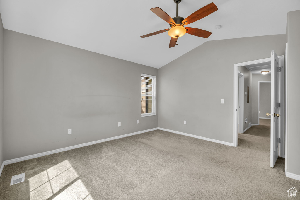 Unfurnished room with vaulted ceiling, ceiling fan, and carpet floors