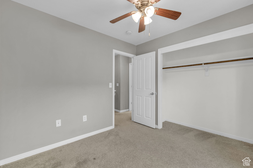 Unfurnished bedroom with a closet, ceiling fan, and carpet floors