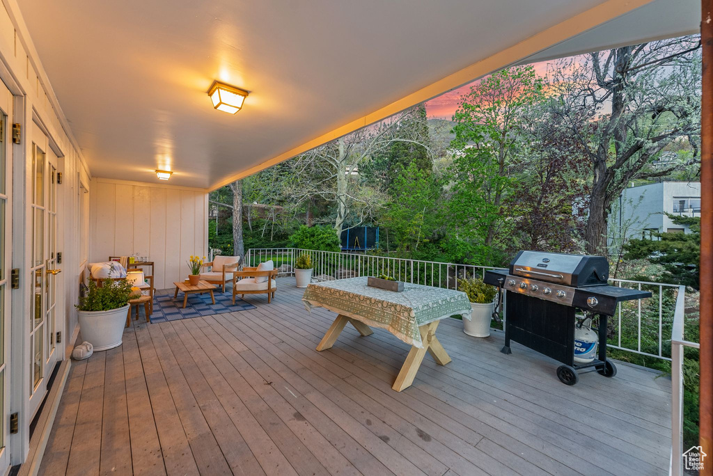 Deck at dusk featuring area for grilling and outdoor lounge area
