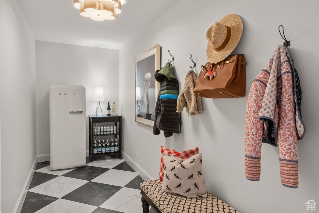 Mudroom featuring tile flooring and a chandelier