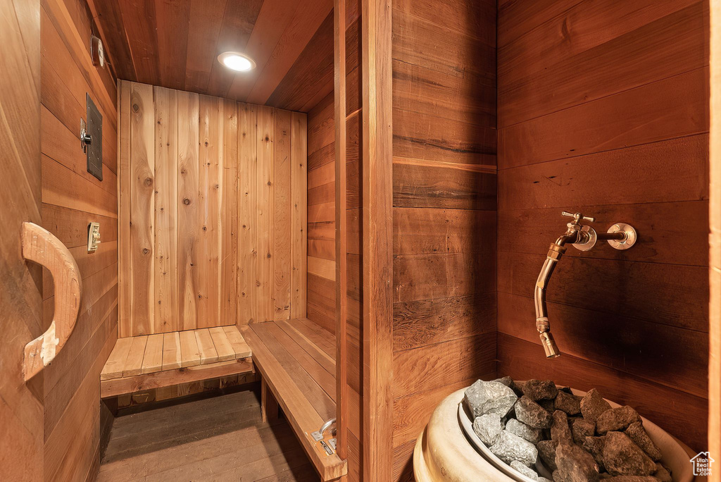 View of sauna / steam room with wood walls, hardwood / wood-style flooring, and wood ceiling