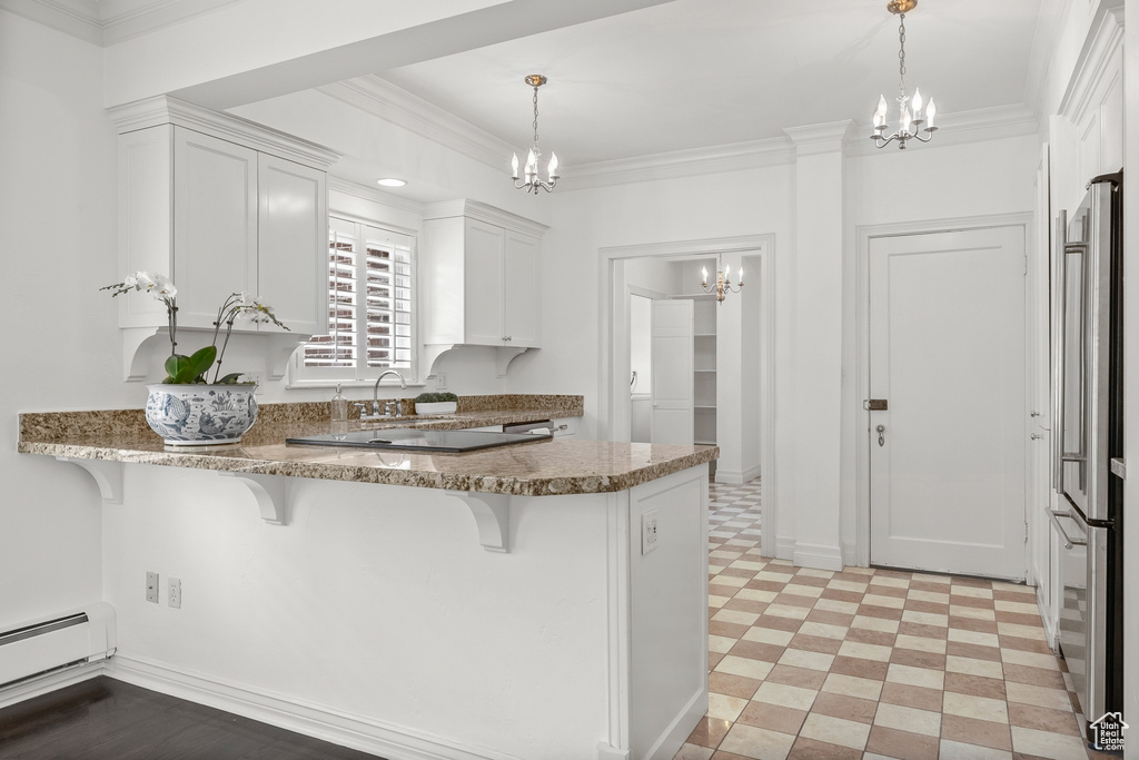 Kitchen featuring a kitchen breakfast bar, pendant lighting, white cabinets, light tile flooring, and kitchen peninsula