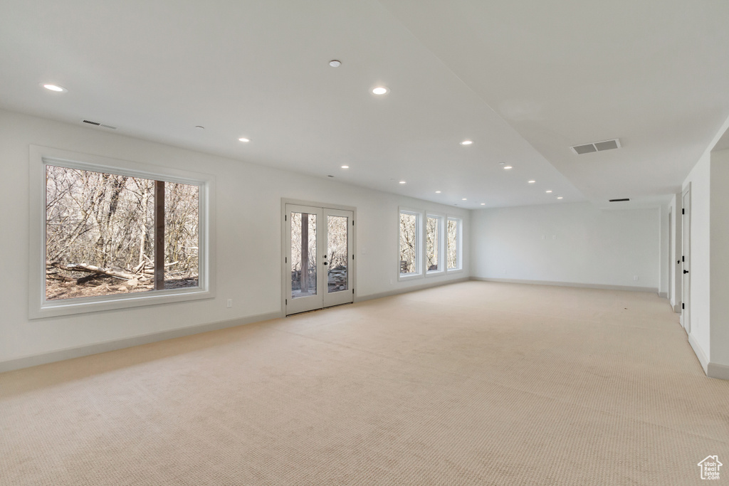 Unfurnished room featuring french doors and light carpet