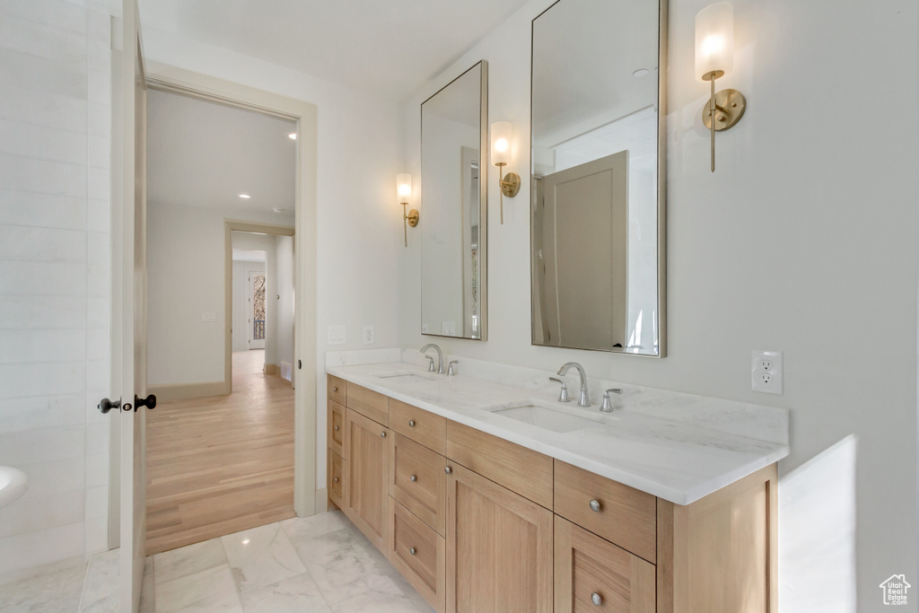 Bathroom with double sink, wood-type flooring, and large vanity