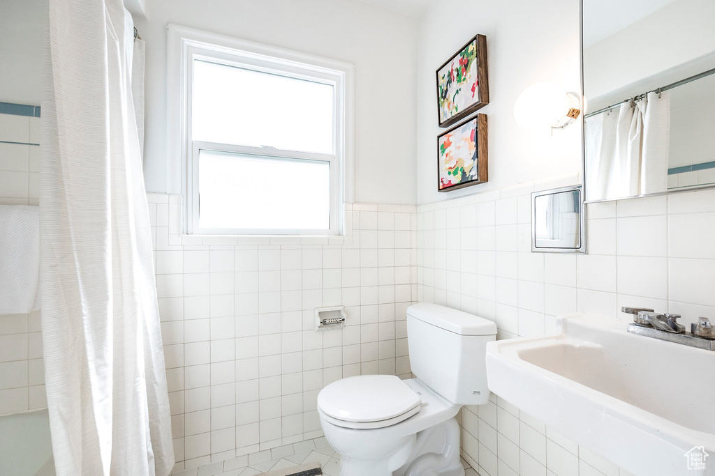 Full bathroom featuring tile walls, sink, tile floors, and toilet