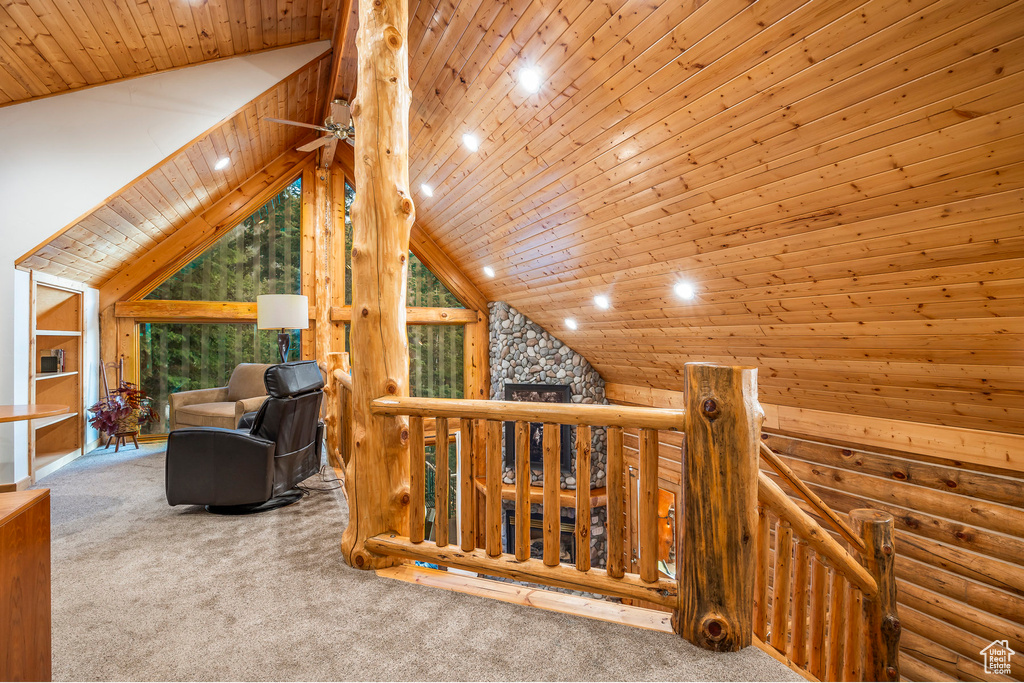Interior space with wooden ceiling, lofted ceiling, log walls, and carpet flooring