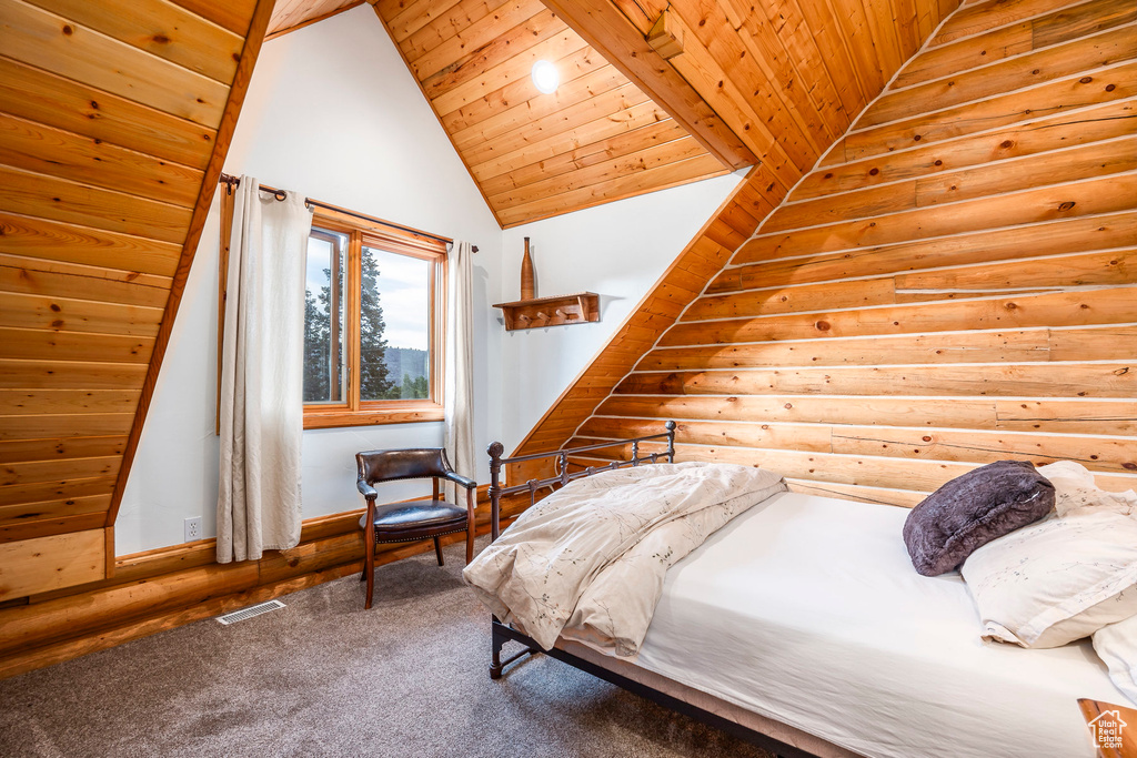 Bedroom with carpet floors, vaulted ceiling, log walls, and wooden ceiling