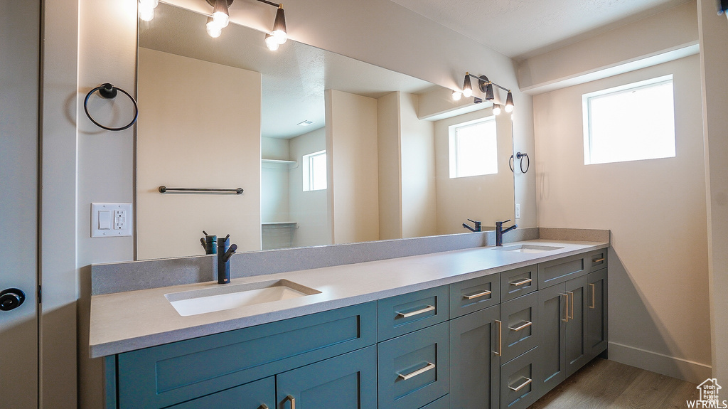 Bathroom featuring hardwood / wood-style flooring and dual vanity