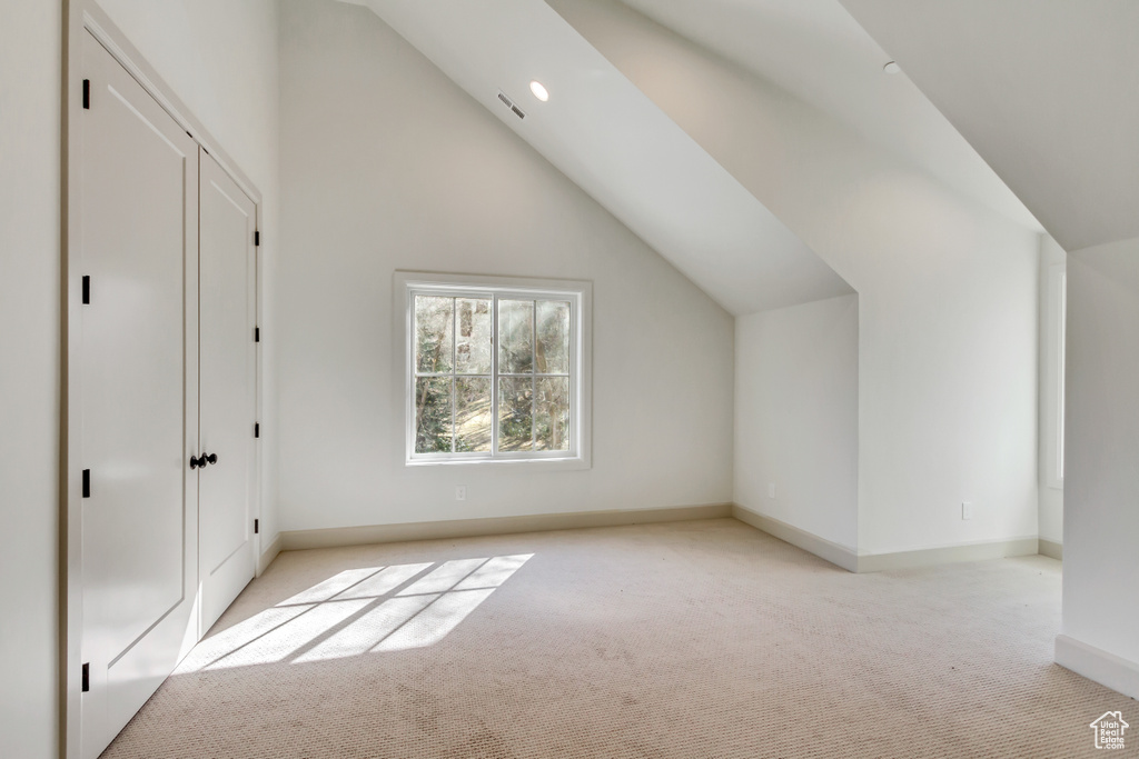 Bonus room featuring light colored carpet and vaulted ceiling