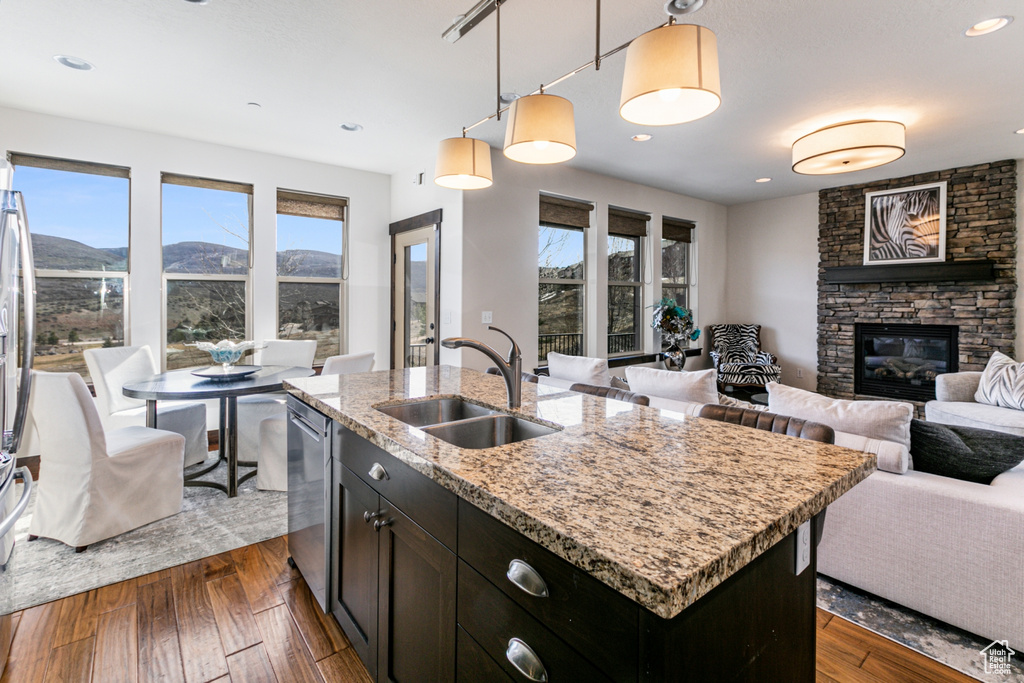 Kitchen with a mountain view, a fireplace, sink, dark hardwood / wood-style floors, and a center island with sink