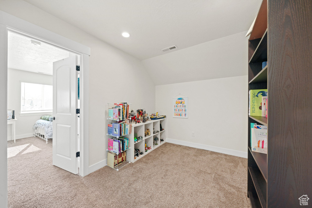 Playroom featuring light colored carpet and vaulted ceiling