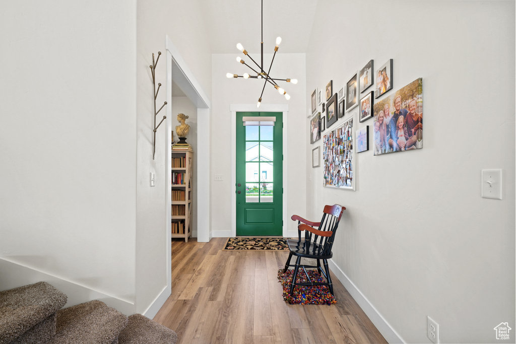 Entrance foyer featuring hardwood / wood-style floors and an inviting chandelier
