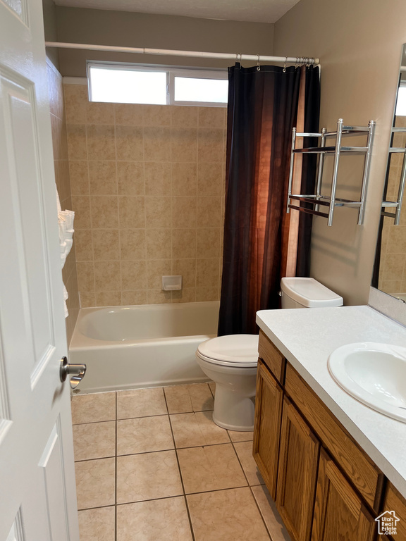 Full bathroom with toilet, tile floors, vanity, and shower / tub combo with curtain