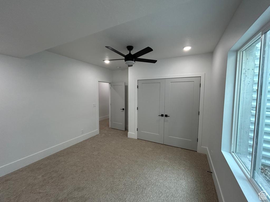 Empty room with carpet flooring and ceiling fan