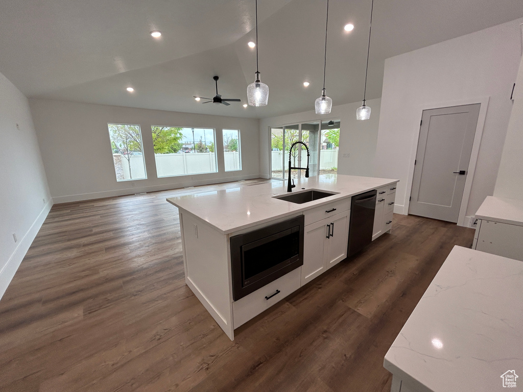 Kitchen with dishwasher, stainless steel microwave, a kitchen island with sink, sink, and dark hardwood / wood-style flooring