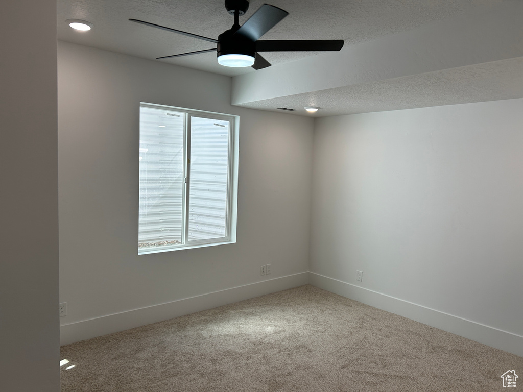 Spare room with a textured ceiling, ceiling fan, and carpet floors