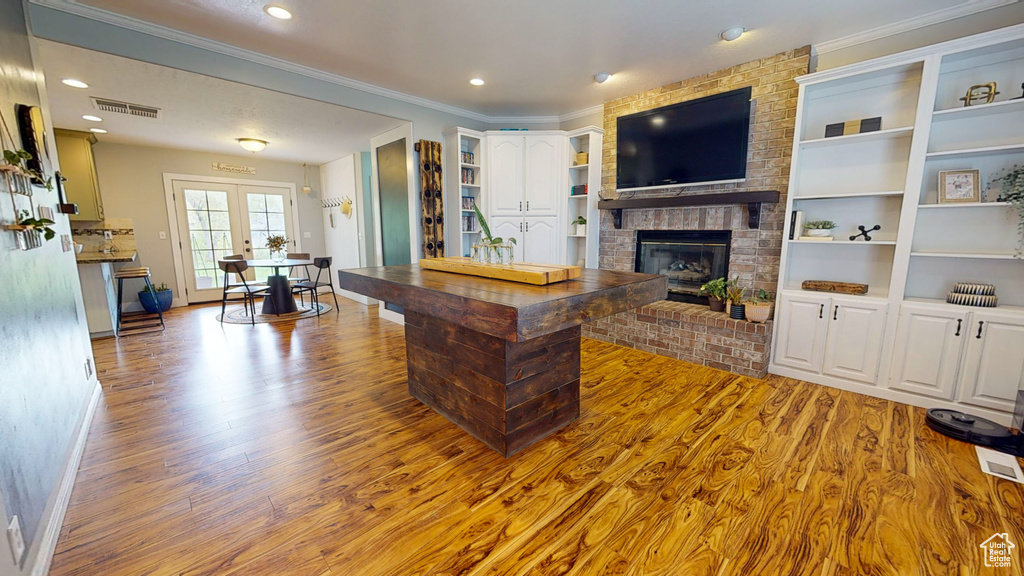 Living room featuring built in shelves, a brick fireplace, and dark hardwood / wood-style floors