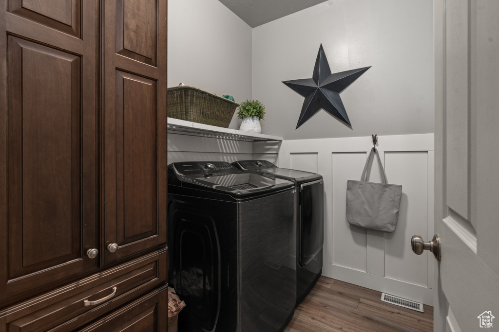 Laundry area with independent washer and dryer and hardwood / wood-style floors