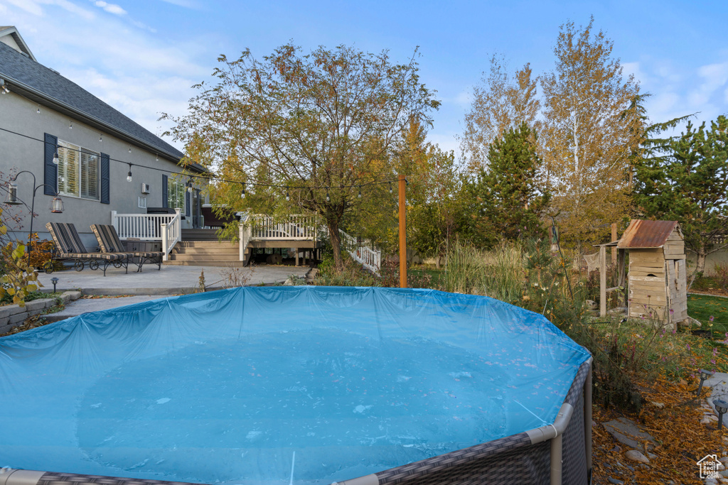 View of pool with a wooden deck and a patio area