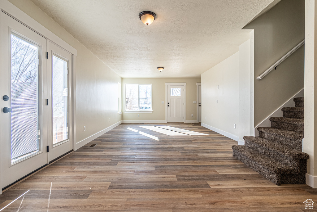 Entryway with wood-type flooring and a textured ceiling
