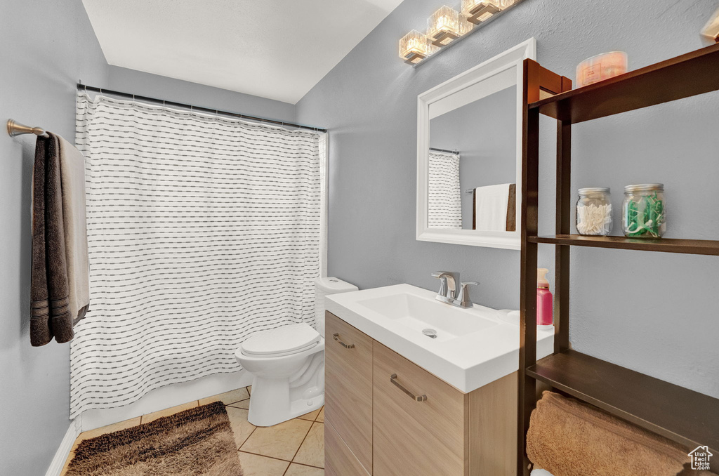 Bathroom featuring vanity, tile floors, and toilet
